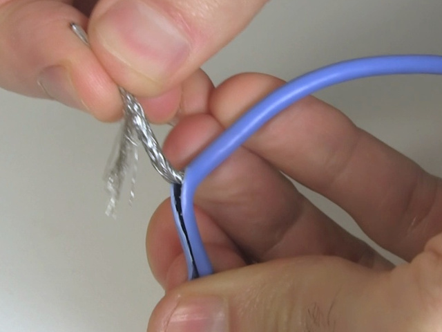 Peeling back the jacket on the USB cable, exposing the insides.