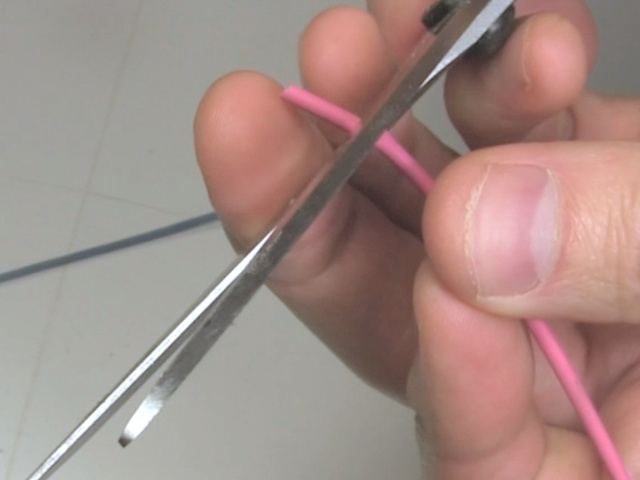 Cutting heat shrink tubing using scissors.