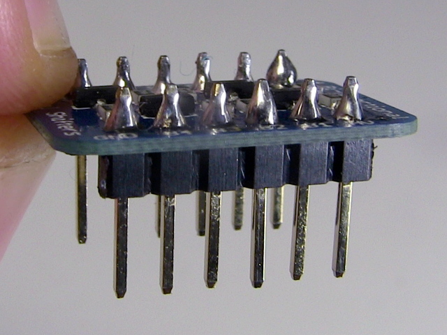 Male pin headers soldered to a level shifter board.