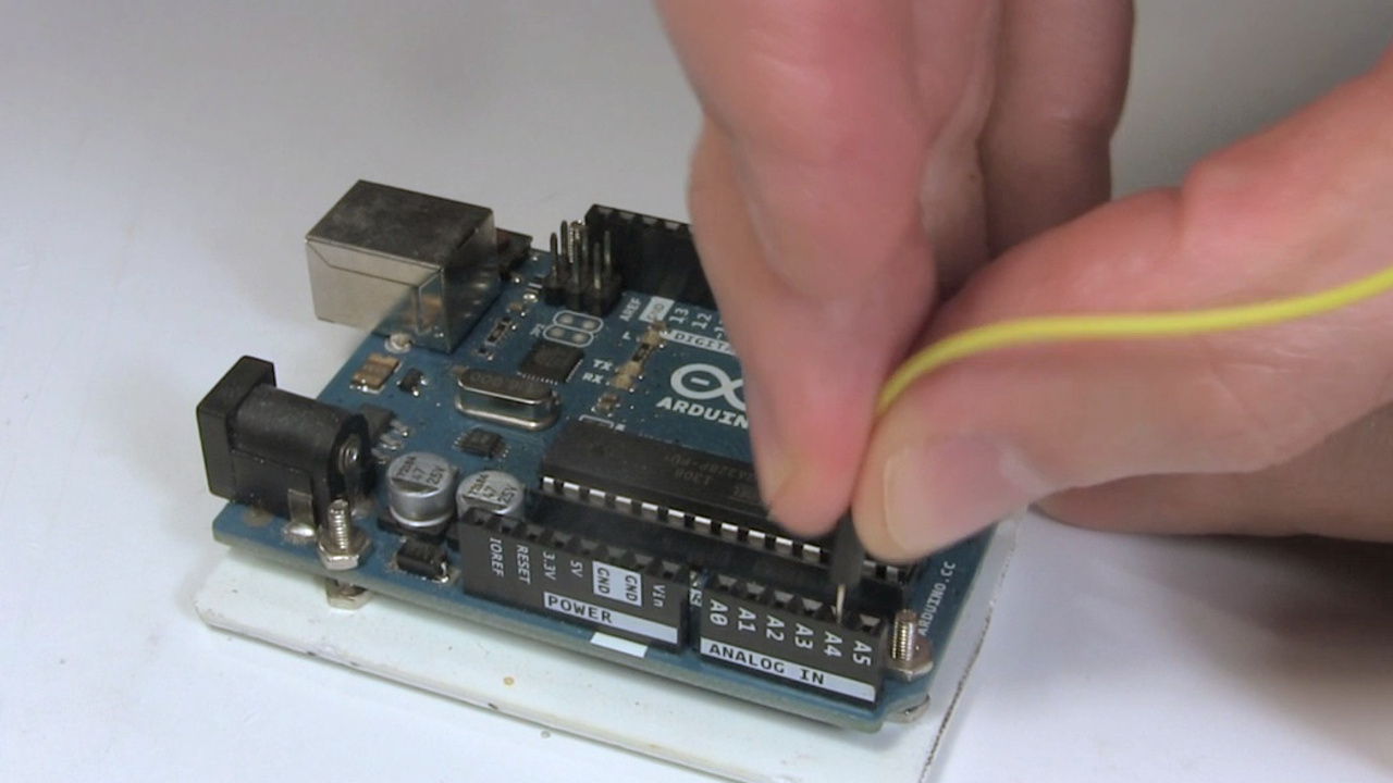 Connecting a jumper wire to a female pin header on the Arduino.