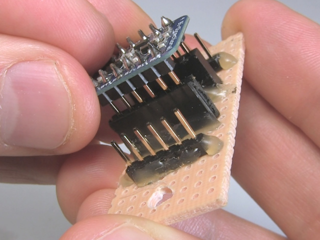 Plugging a board with male pin headers into the female pin headers of another board, showing that they have the same spacing.