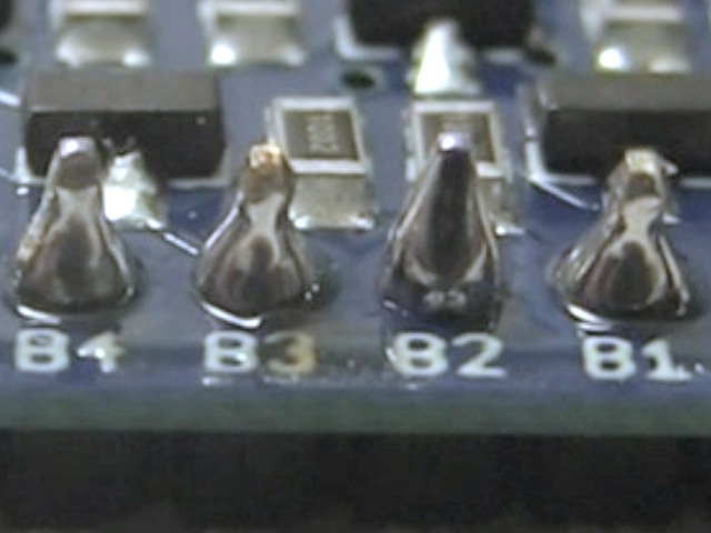 A close-up of the soldered pads and pins showing the conical shaped solder.