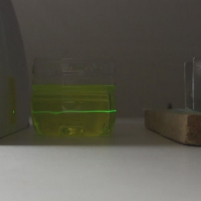 TEA laser's ultraviolet laser beam fluorescing in a container of fluorescein and water.