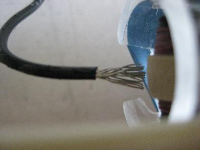 Wire brush facing a belt in a Van de Graaff generator.